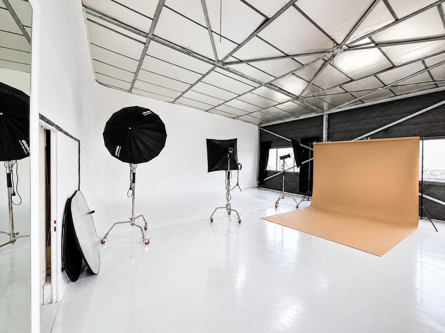 Plateau du studio Muze à Ivry-sur-Seine : sol blanc, verrière, flashs et fond papier camel