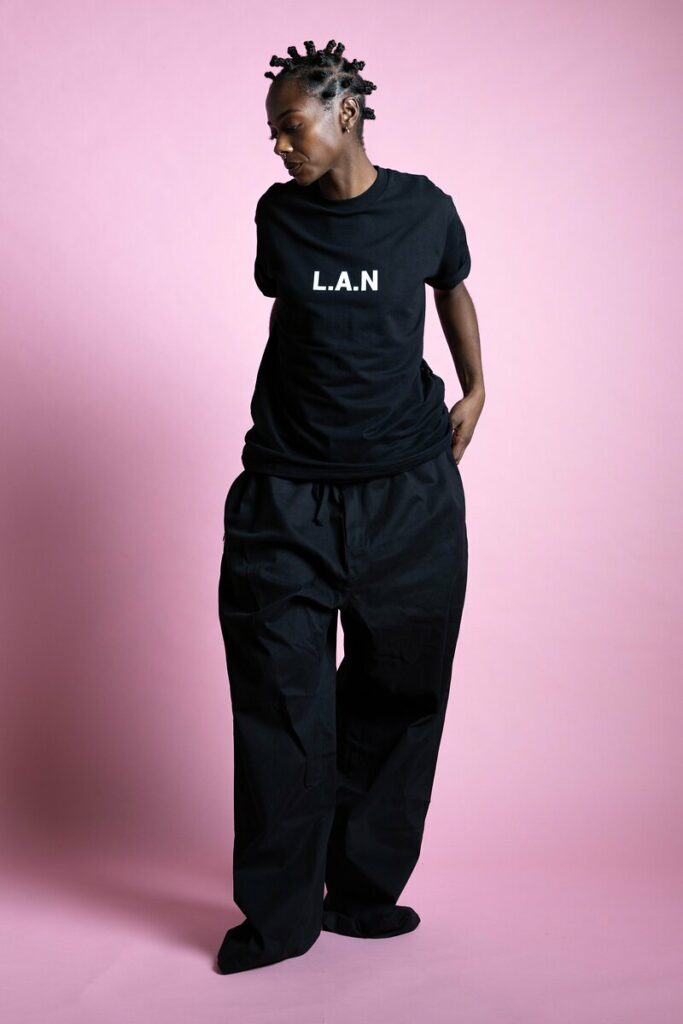 Shooting mode : mannequin en t-shirt noir, pose en pied sur fond rose au studio Muze à Ivry-sur-Seine